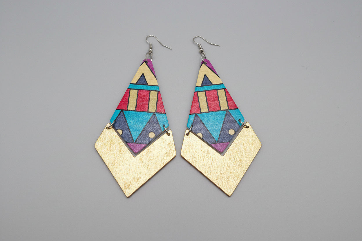 Geometric patterned earrings with gold accents on a reflective gray surface